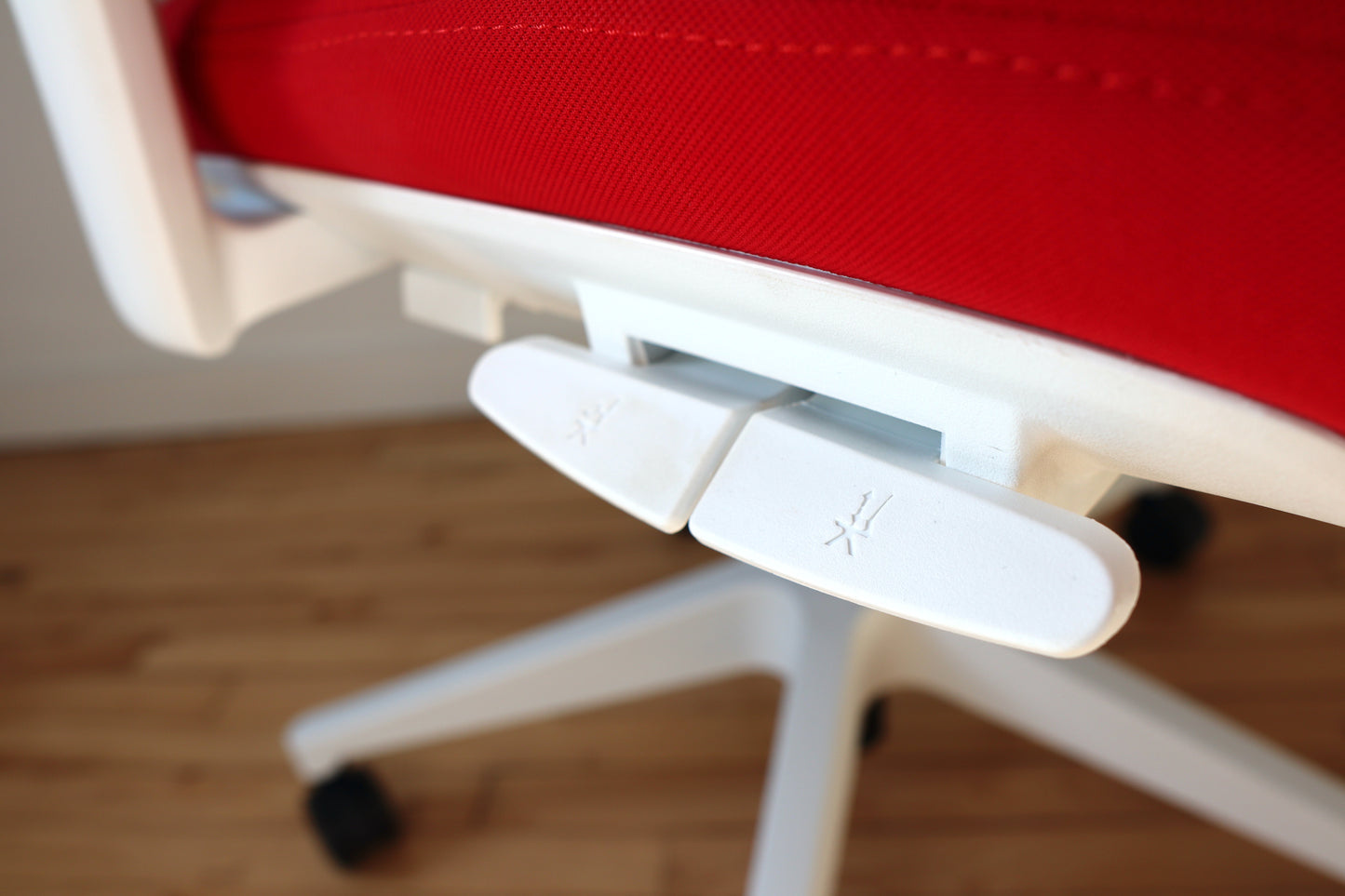 White and red office chair tilt and gas lift control closeup