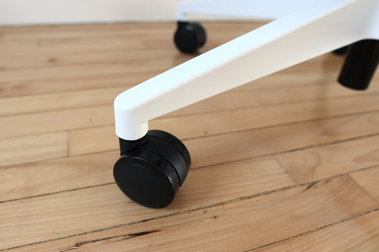 White ergonomic office chair nylon castor wheel closeup