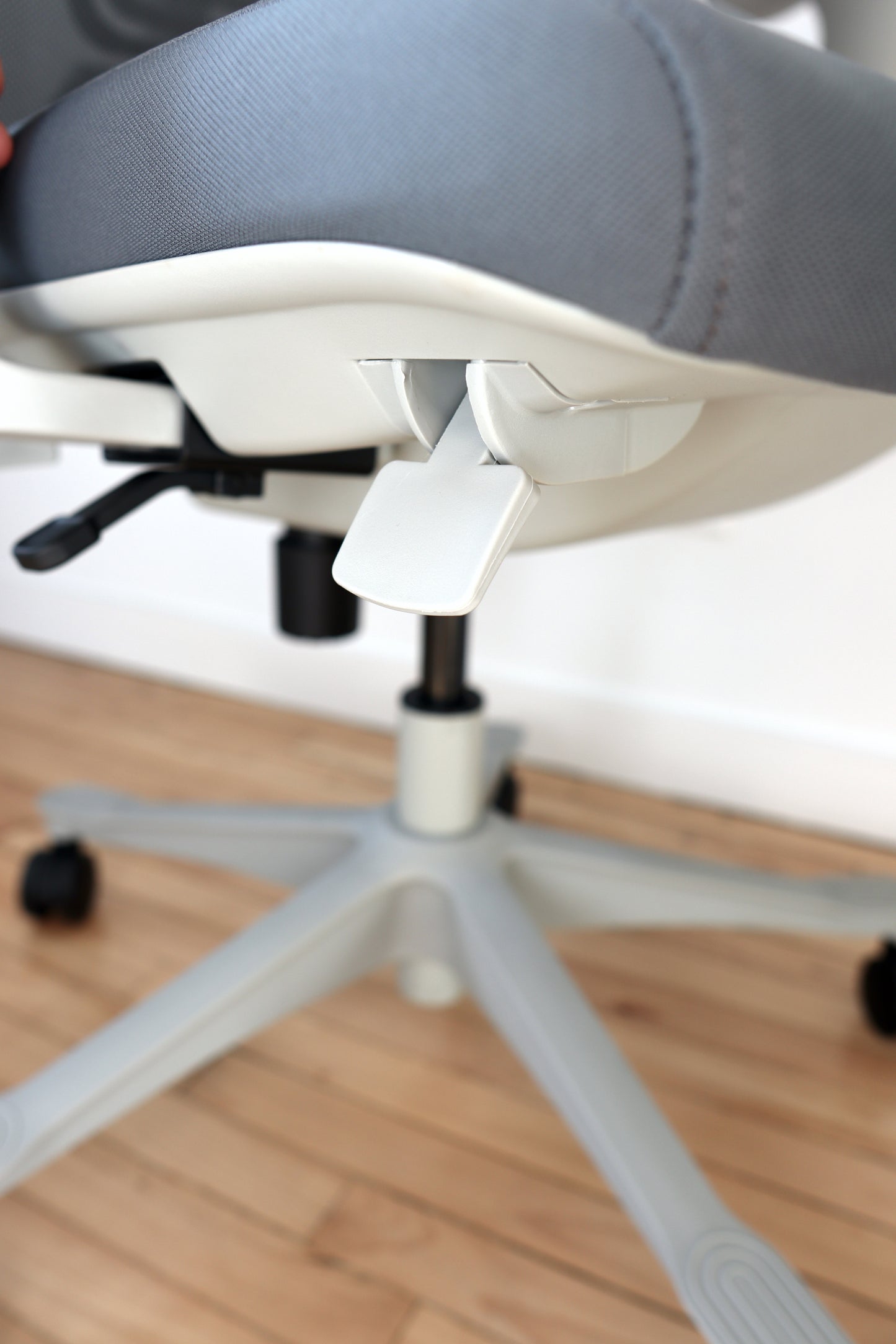 Grey adjustable office chair gas lift height control closeup